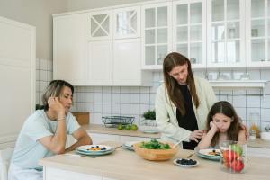 A father and mother discuss divorce with their child while eating breakfast at a kitchen counter